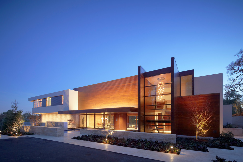 Cette image montre une grande façade de maison minimaliste à un étage avec un revêtement mixte et un toit plat.