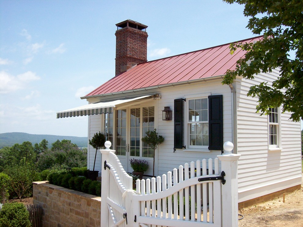 На фото: маленький, одноэтажный, деревянный, белый дом в классическом стиле с красной крышей для на участке и в саду с
