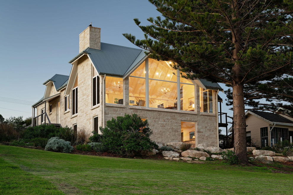 Foto della villa contemporanea a due piani con rivestimento in pietra e copertura in metallo o lamiera