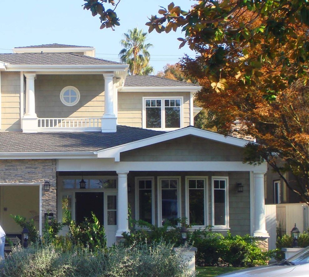 Immagine della villa grande beige stile marinaro a due piani con tetto a capanna e copertura a scandole