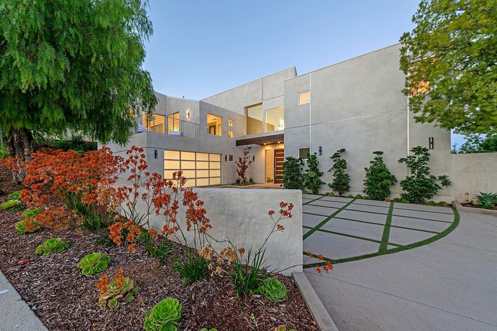 Imagen de fachada de casa blanca minimalista grande de dos plantas con revestimiento de estuco