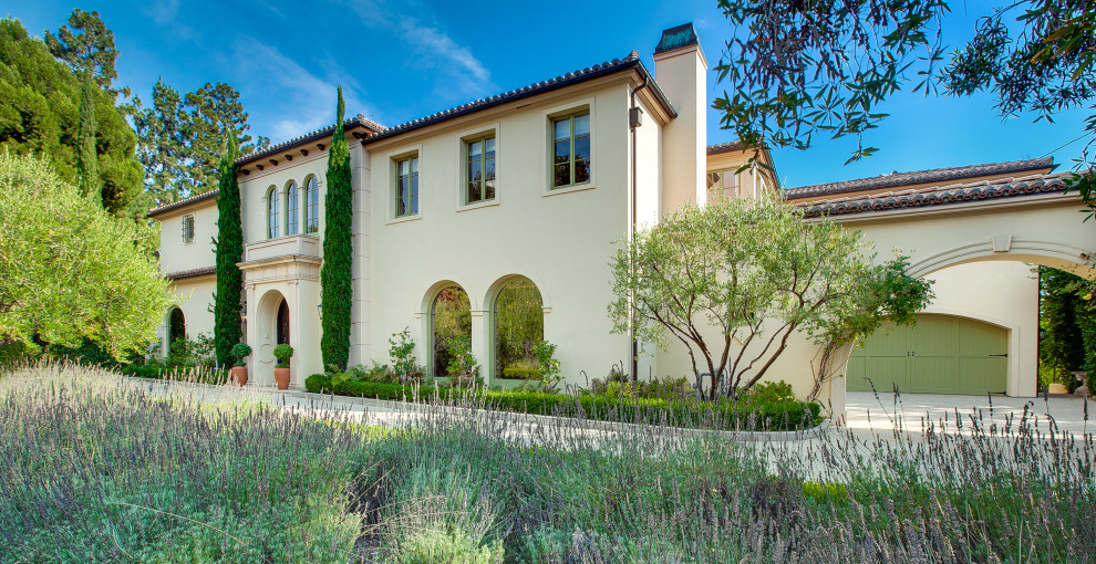 Zweistöckiges Mediterranes Einfamilienhaus mit beiger Fassadenfarbe, Walmdach und Ziegeldach in Los Angeles