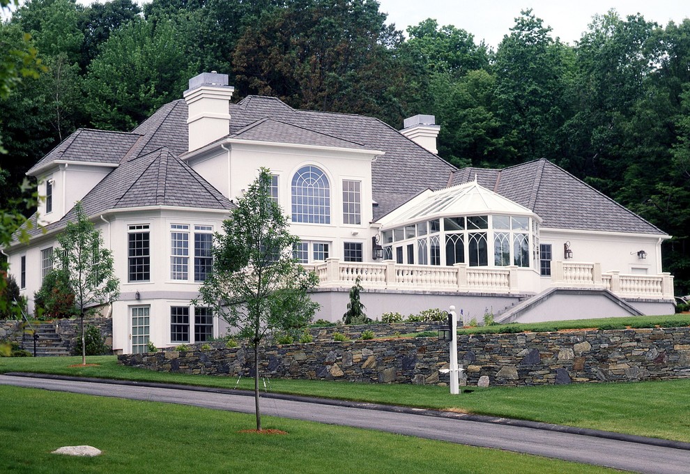 Стильный дизайн: большой, двухэтажный, белый дом в классическом стиле с облицовкой из цементной штукатурки - последний тренд