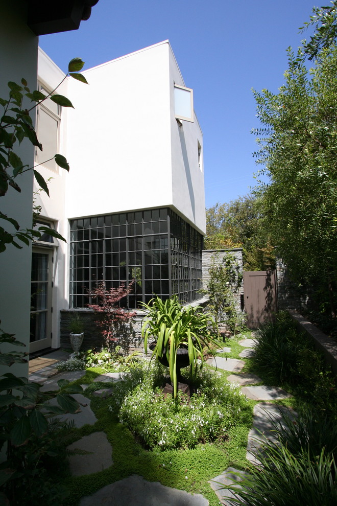 Immagine della facciata di una casa contemporanea con rivestimento in pietra