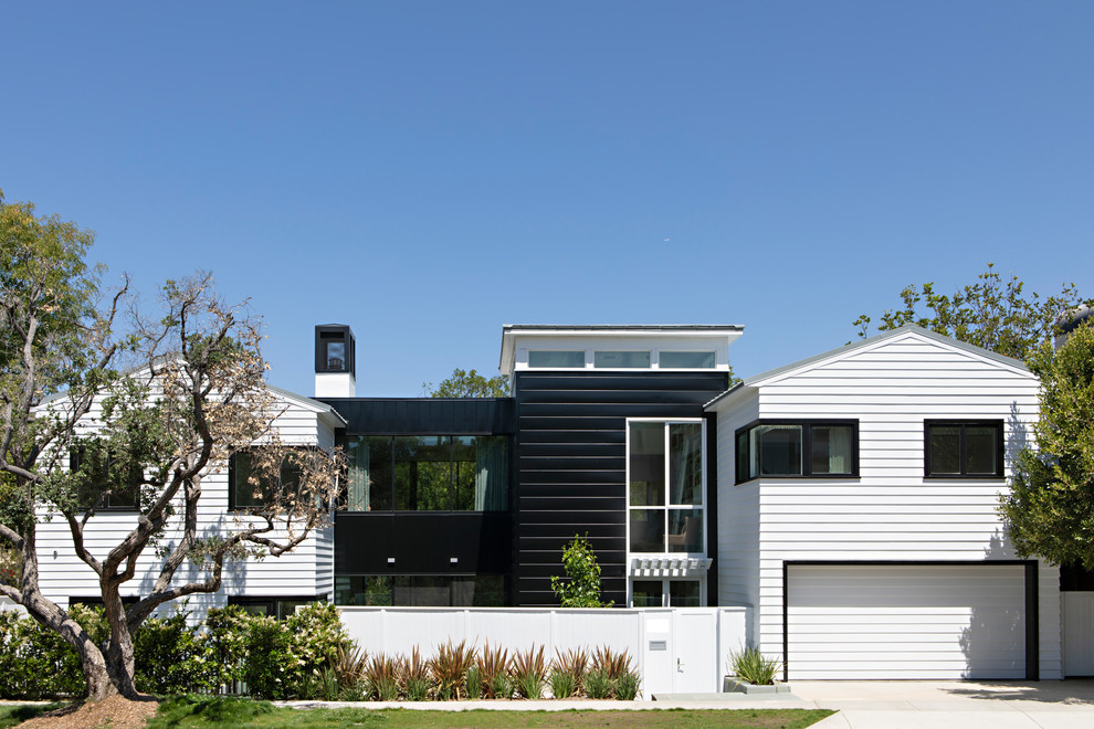 Imagen de fachada de casa multicolor actual de dos plantas con tejado a dos aguas