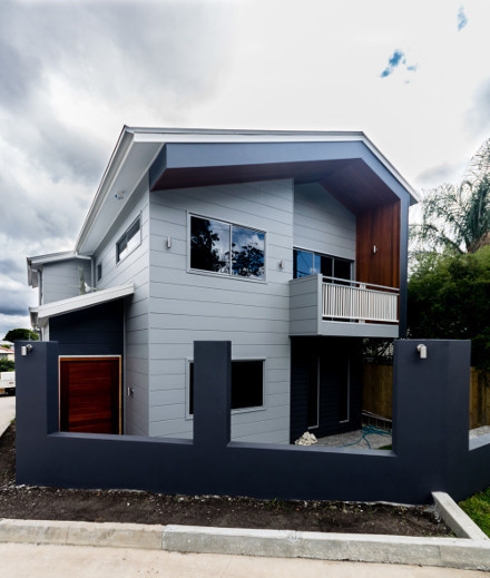 Inspiration för ett funkis grått hus, med två våningar och blandad fasad