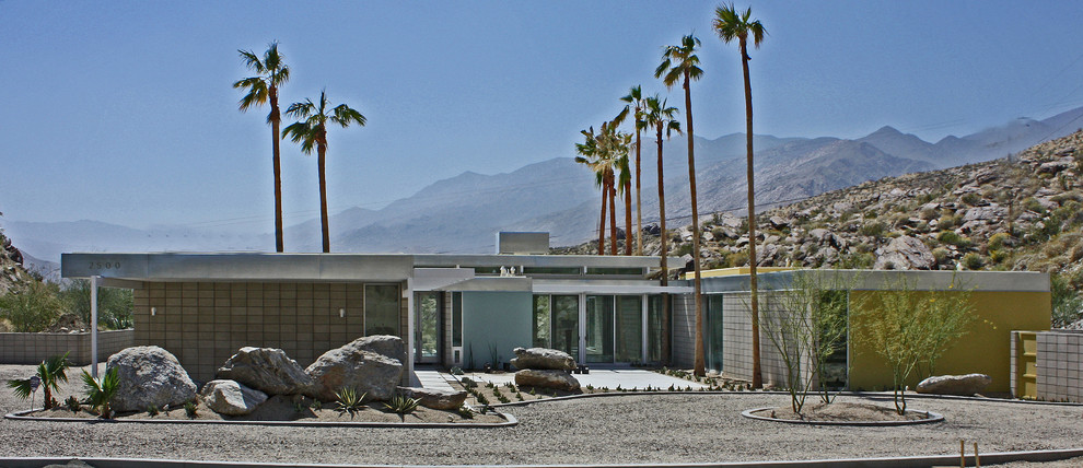 Cette photo montre une grande façade de maison bleue rétro en stuc de plain-pied avec un toit plat.