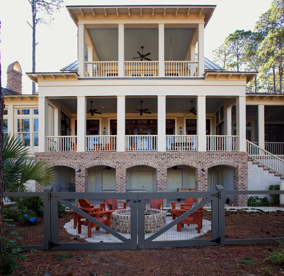 Photo of an expansive and beige nautical brick house exterior in Charleston with three floors.
