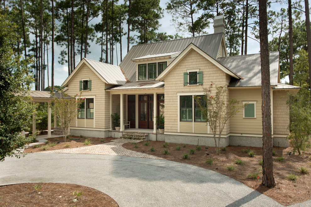 Foto de fachada beige costera de tamaño medio de dos plantas con revestimientos combinados y tejado a dos aguas