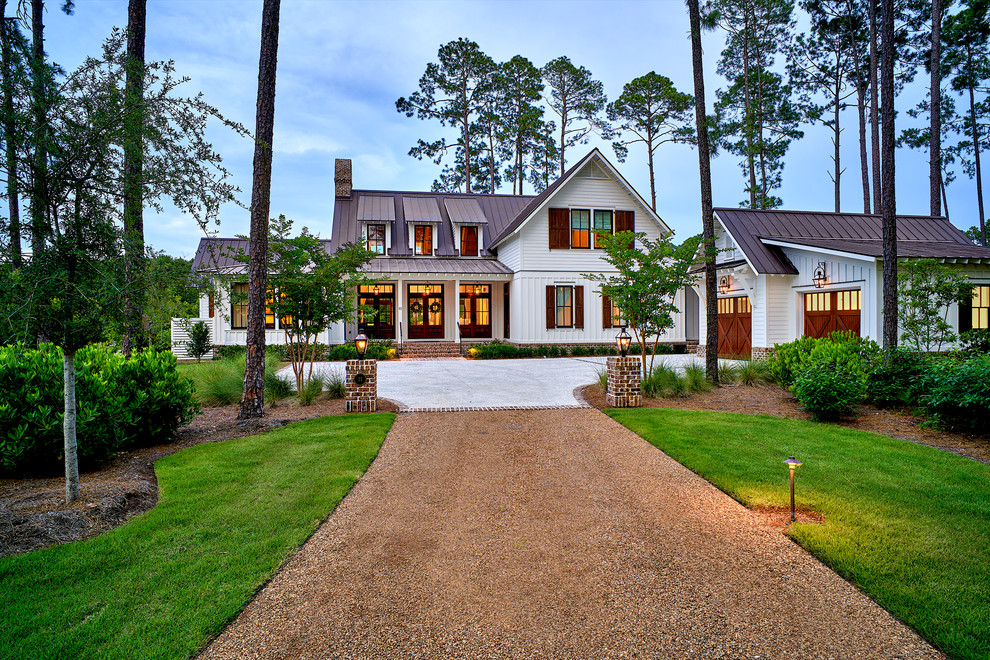 Idée de décoration pour une grande façade de maison blanche champêtre en panneau de béton fibré à un étage avec un toit à deux pans.