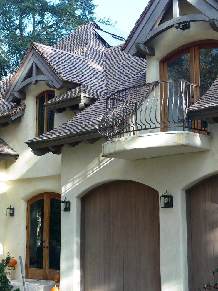 Foto de fachada de casa beige campestre de dos plantas con revestimiento de adobe, tejado a dos aguas y tejado de teja de madera