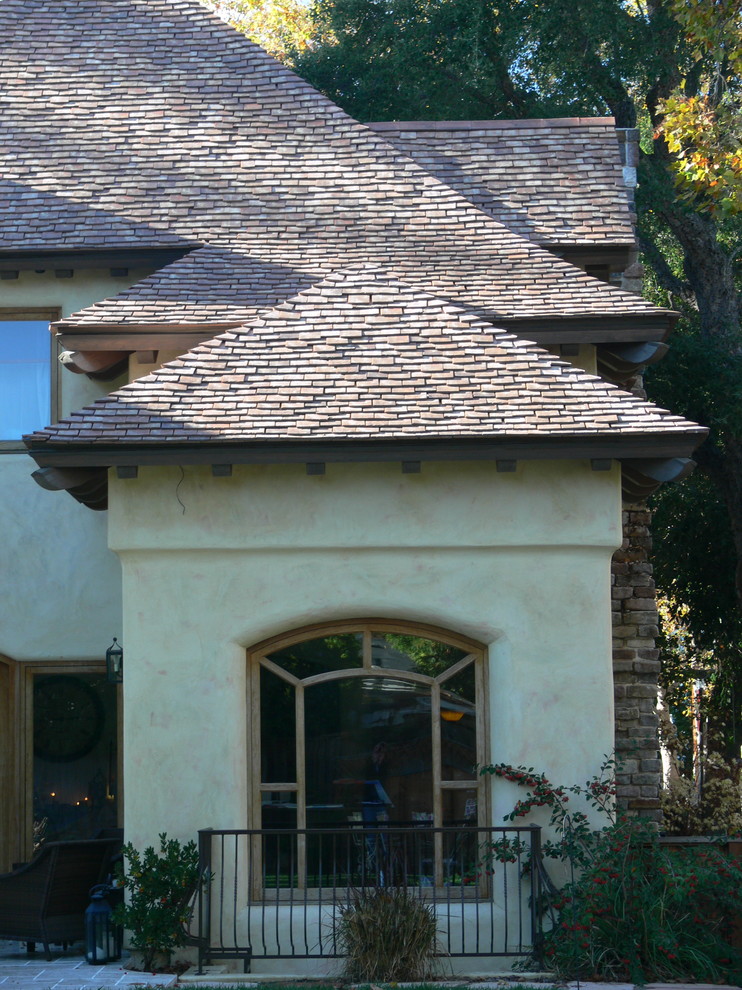 Foto de fachada de casa beige de estilo de casa de campo de dos plantas con revestimiento de adobe, tejado a dos aguas y tejado de teja de madera