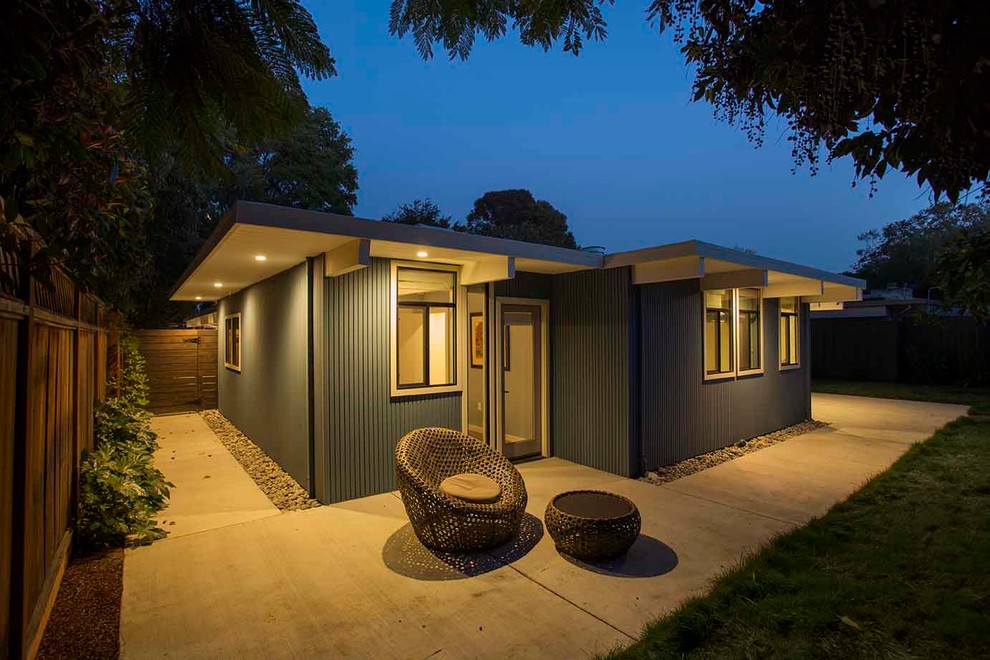 Réalisation d'une façade de maison bleue vintage en bois de taille moyenne et de plain-pied avec un toit plat.