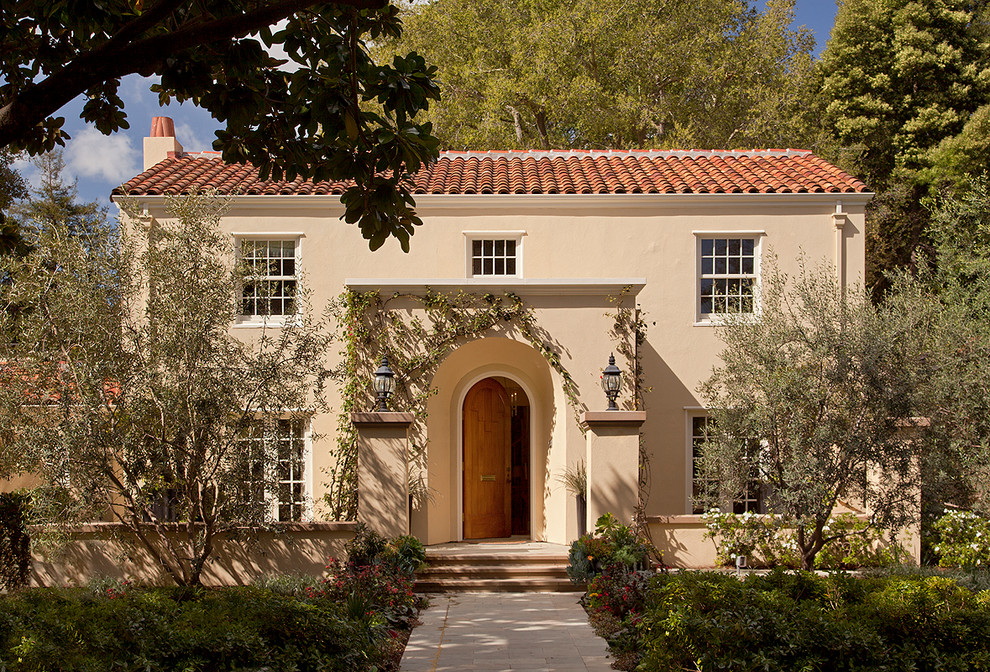 Immagine della facciata di una casa beige mediterranea a due piani