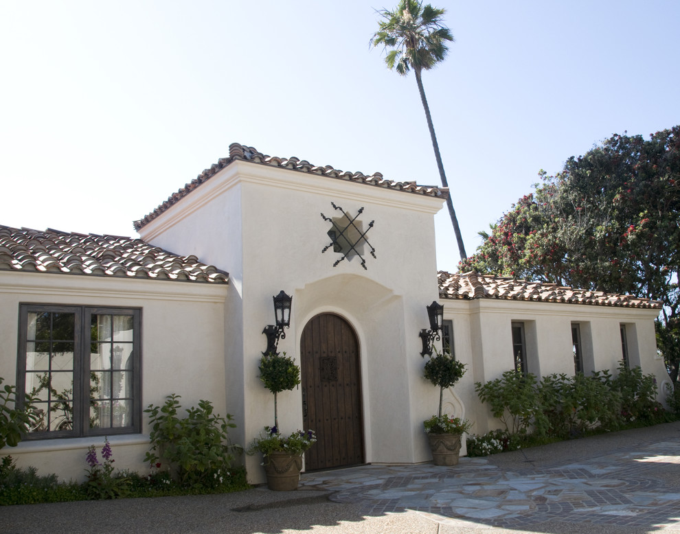 Inspiration for a large mediterranean white one-story stucco house exterior remodel in San Diego with a hip roof