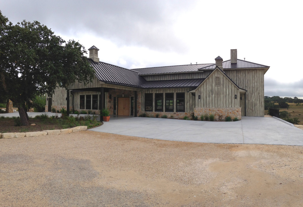 Example of a huge country gray two-story wood gable roof design in Austin