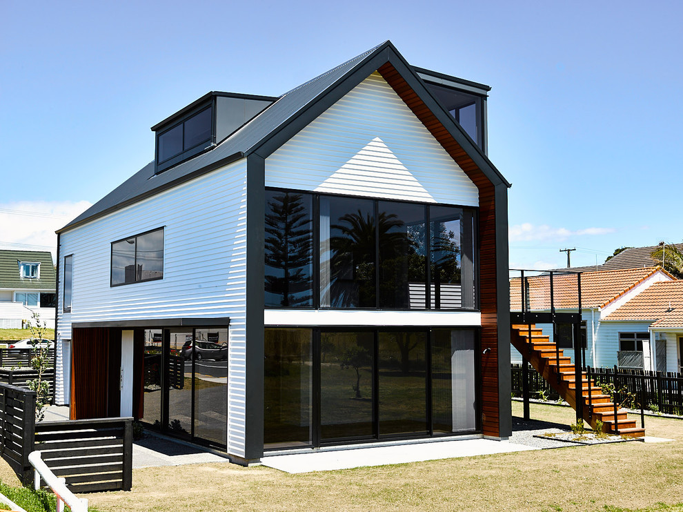 Пример оригинального дизайна: трехэтажный, деревянный, белый таунхаус среднего размера в современном стиле с двускатной крышей и металлической крышей