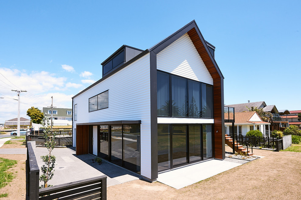 На фото: трехэтажный, деревянный, белый таунхаус среднего размера в современном стиле с двускатной крышей и металлической крышей с