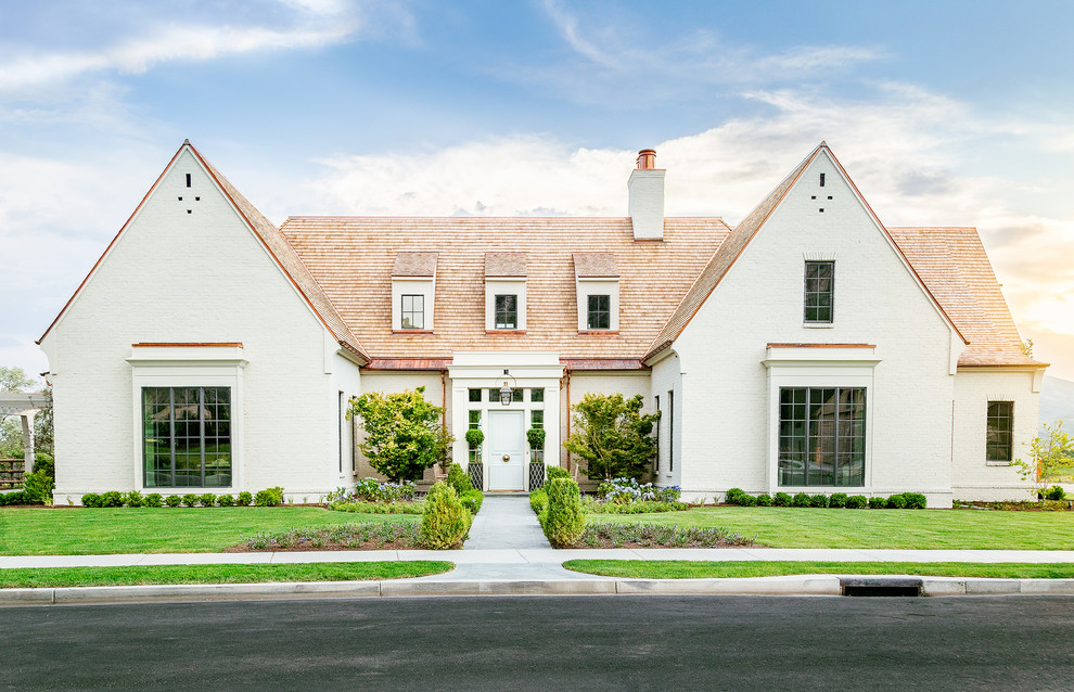 Inspiration for a large timeless beige two-story brick exterior home remodel in Salt Lake City with a shingle roof