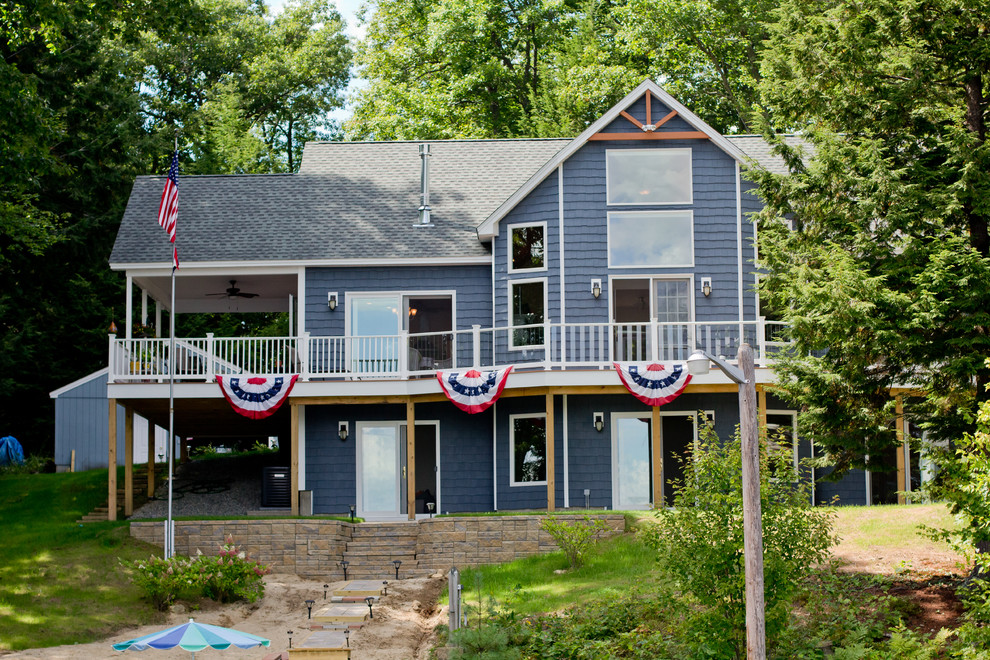 Cette image montre une façade de maison bleue craftsman de taille moyenne et à un étage avec un revêtement en vinyle et un toit à deux pans.