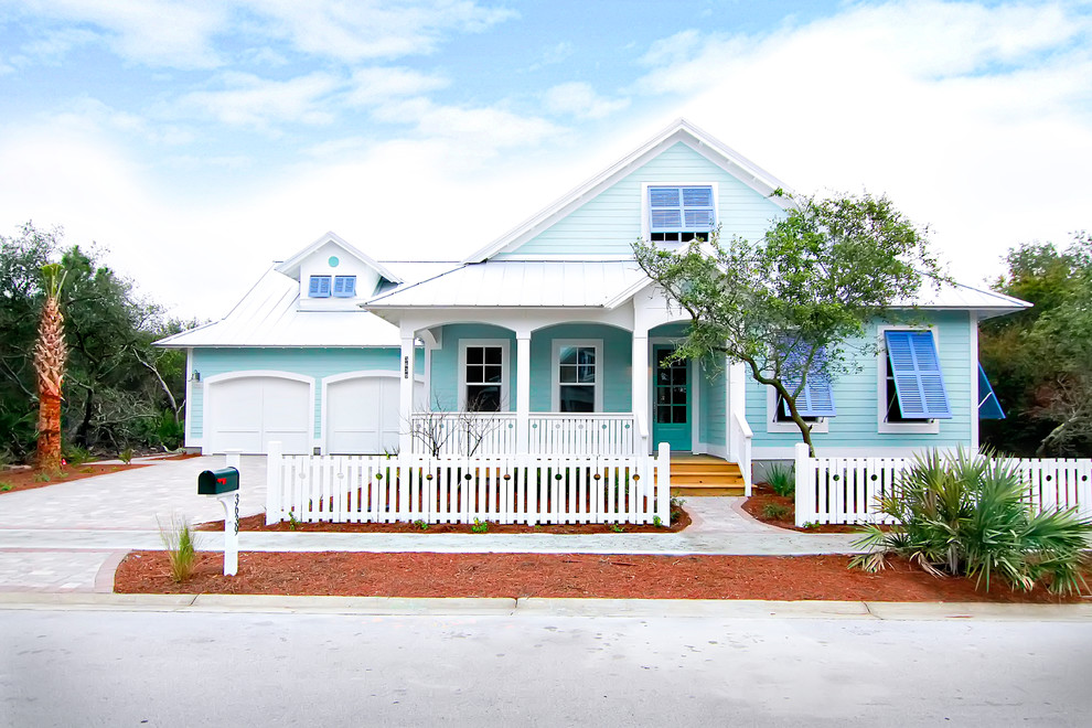 Diseño de fachada de casa azul marinera de tamaño medio de una planta con revestimiento de madera y tejado de metal