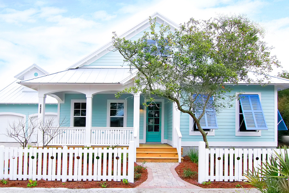 Modelo de fachada de casa azul costera grande de dos plantas con revestimiento de madera y tejado a dos aguas