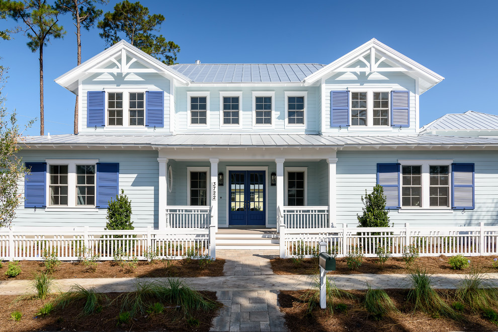 Ejemplo de fachada de casa azul costera grande de dos plantas con revestimiento de madera, tejado a dos aguas y tejado de metal