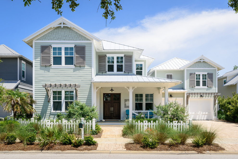 Zweistöckiges Maritimes Einfamilienhaus mit Mix-Fassade, grüner Fassadenfarbe, Walmdach, Blechdach und weißem Dach in Jacksonville