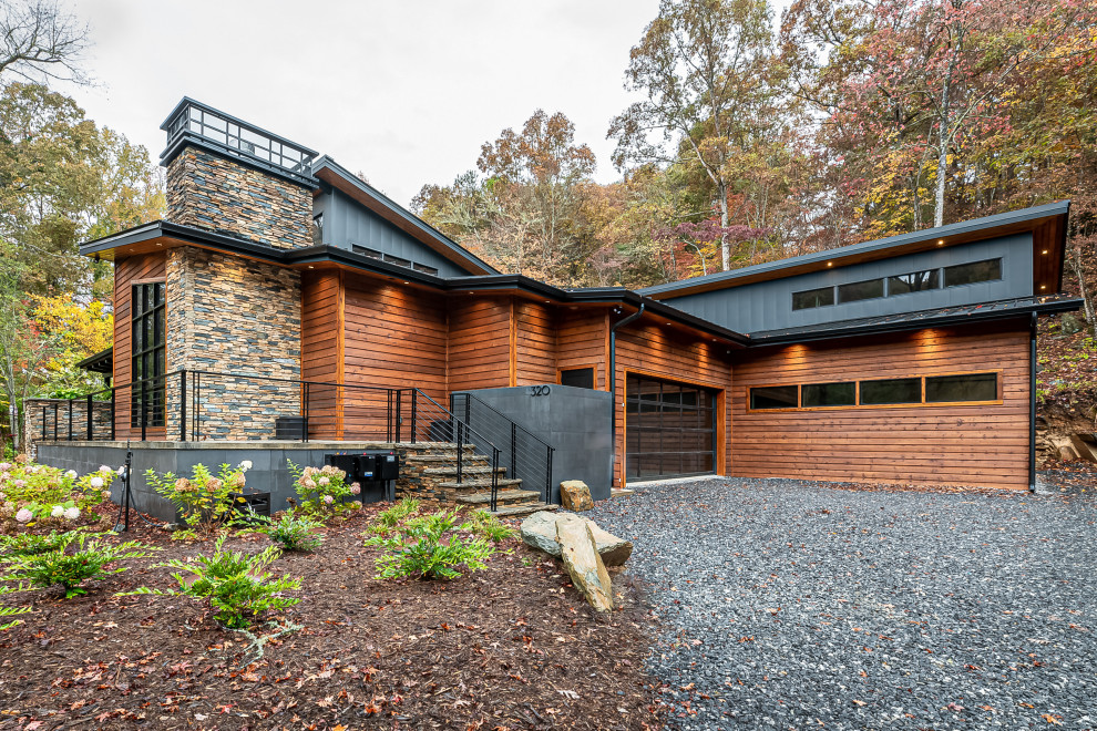 Idée de décoration pour une grande façade de maison multicolore chalet à un étage avec un revêtement mixte, un toit en appentis et un toit en métal.