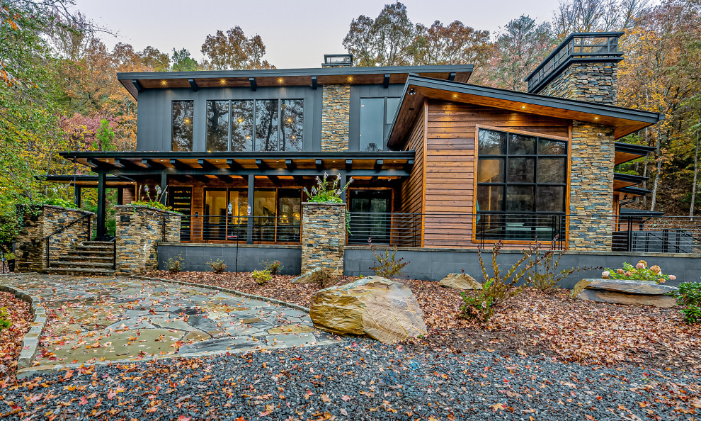 Cette photo montre une grande façade de maison multicolore montagne à un étage avec un revêtement mixte, un toit en appentis et un toit en métal.