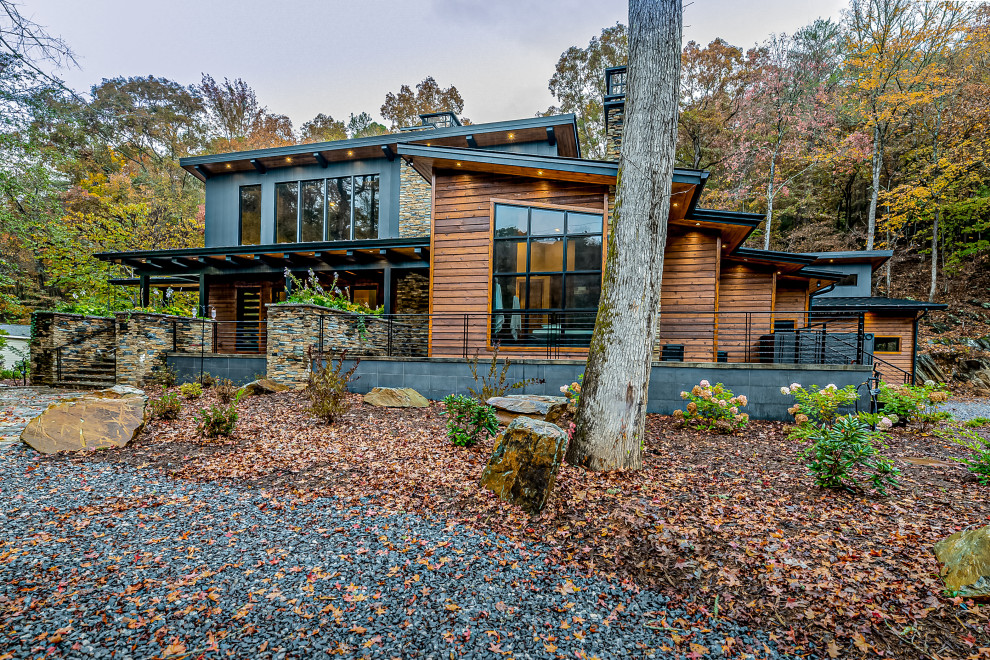 Diseño de fachada de casa multicolor rústica grande de dos plantas con revestimientos combinados, tejado de un solo tendido y tejado de metal