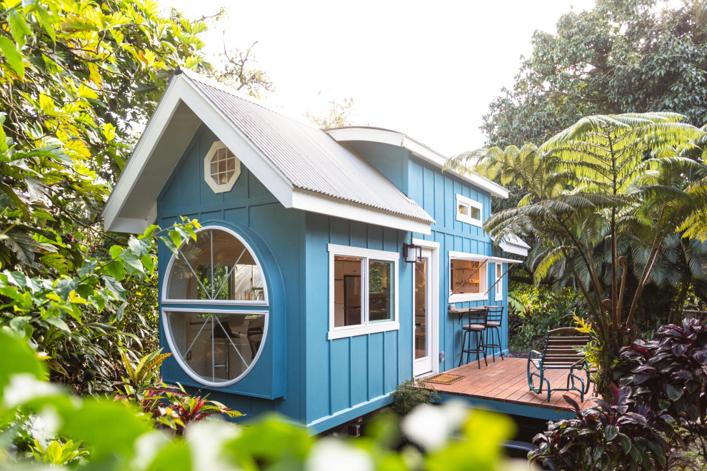 Diseño de fachada de casa azul marinera pequeña con revestimiento de madera y tejado de metal