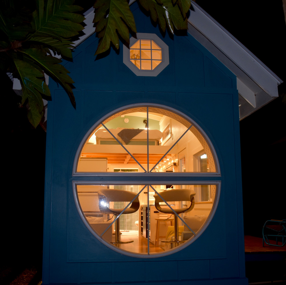 Modelo de fachada de casa azul costera pequeña con revestimiento de madera y tejado de metal