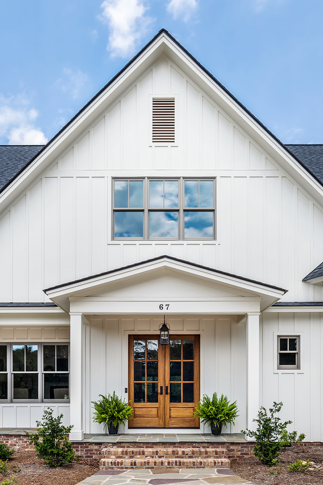 Cette photo montre une façade de maison blanche nature en panneau de béton fibré de taille moyenne et à un étage avec un toit en shingle et un toit à deux pans.