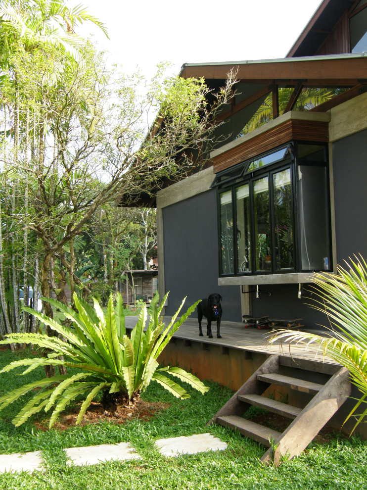 Idee per la villa grigia tropicale a due piani di medie dimensioni con rivestimento in mattoni, tetto a capanna e copertura in metallo o lamiera