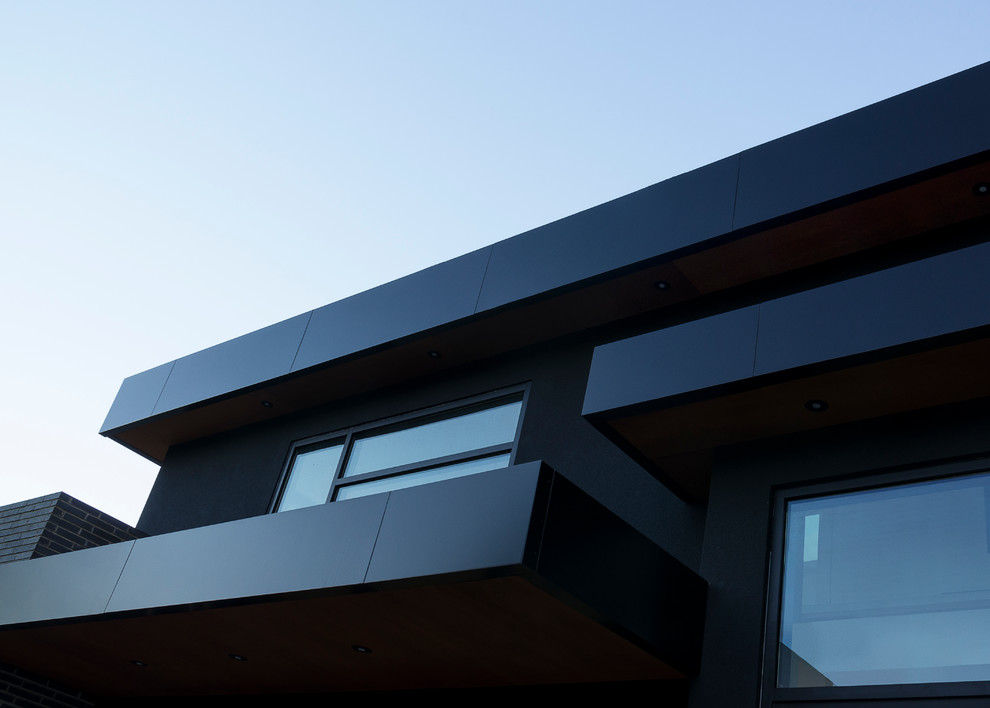 Foto de fachada negra grande con revestimiento de metal y tejado plano