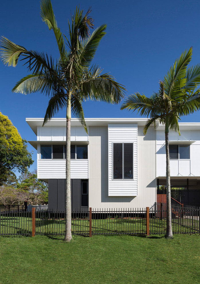 Mittelgroßes, Zweistöckiges Maritimes Einfamilienhaus mit Mix-Fassade, weißer Fassadenfarbe, Flachdach und Blechdach in Brisbane