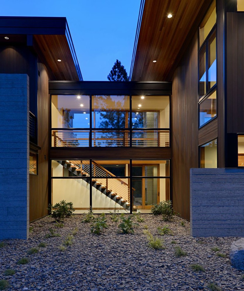 Diseño de fachada marrón minimalista grande de dos plantas con revestimiento de madera y tejado plano