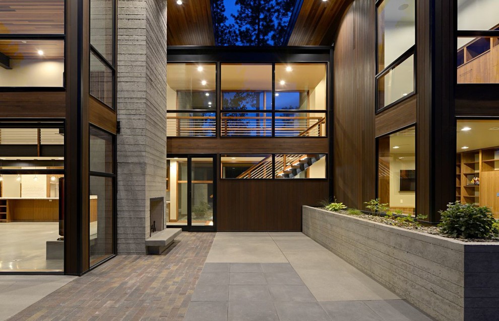 Réalisation d'une grande façade de maison marron minimaliste en bois à un étage avec un toit plat.