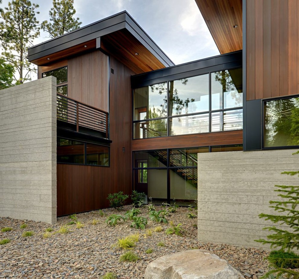 Immagine della facciata di una casa grande marrone moderna a due piani con rivestimento in legno e tetto piano