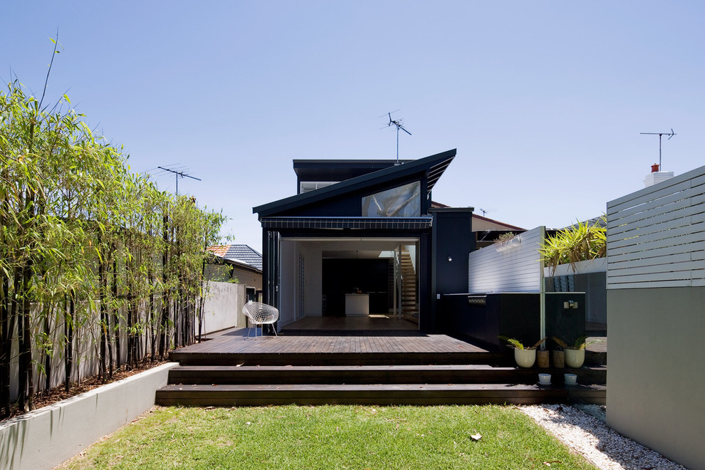 Aménagement d'une façade de maison contemporaine à un étage avec un revêtement mixte et un toit en appentis.