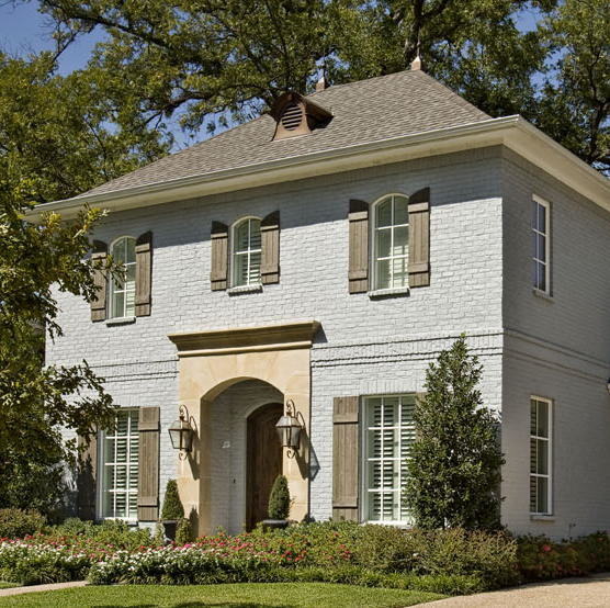 Mittelgroßes, Zweistöckiges Klassisches Haus mit Backsteinfassade, blauer Fassadenfarbe und Walmdach in Dallas