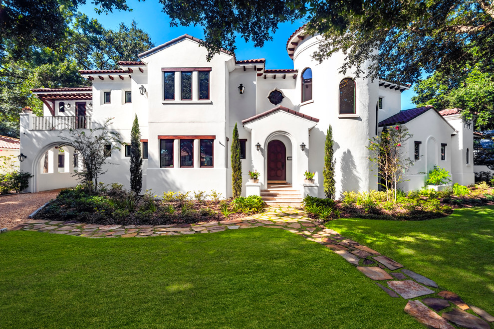 Inspiration for a large mediterranean white two-story stucco house exterior remodel in Tampa with a hip roof, a tile roof and a red roof