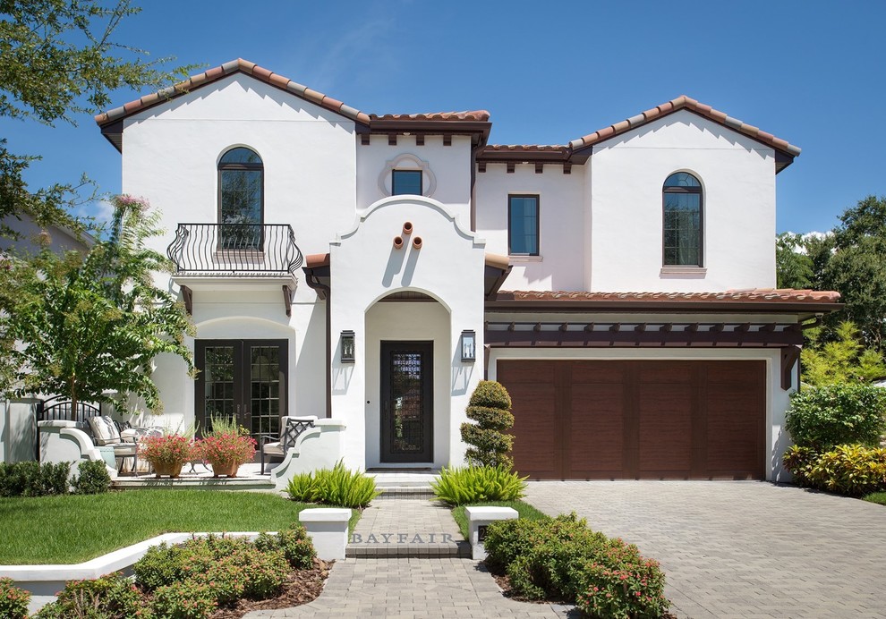 Example of a mid-sized tuscan white two-story stucco exterior home design in Tampa with a tile roof