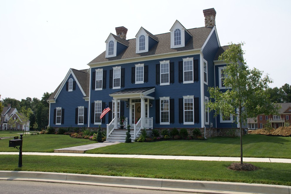 Cette photo montre une grande façade de maison bleue chic à deux étages et plus avec un revêtement en vinyle et un toit à deux pans.