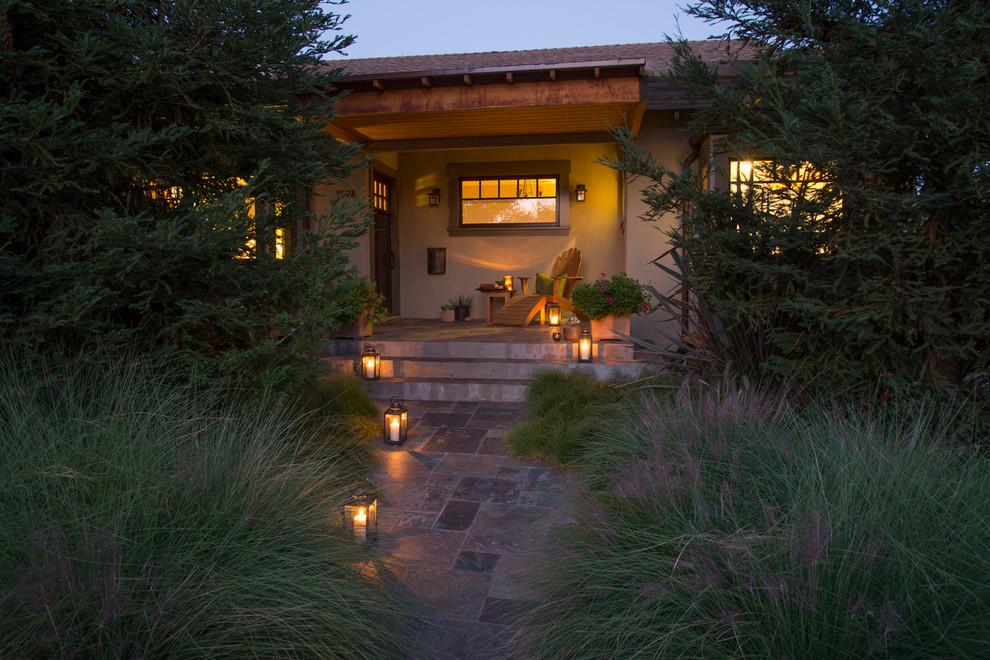 На фото: маленький, одноэтажный, зеленый дом в стиле рустика с комбинированной облицовкой и вальмовой крышей для на участке и в саду с