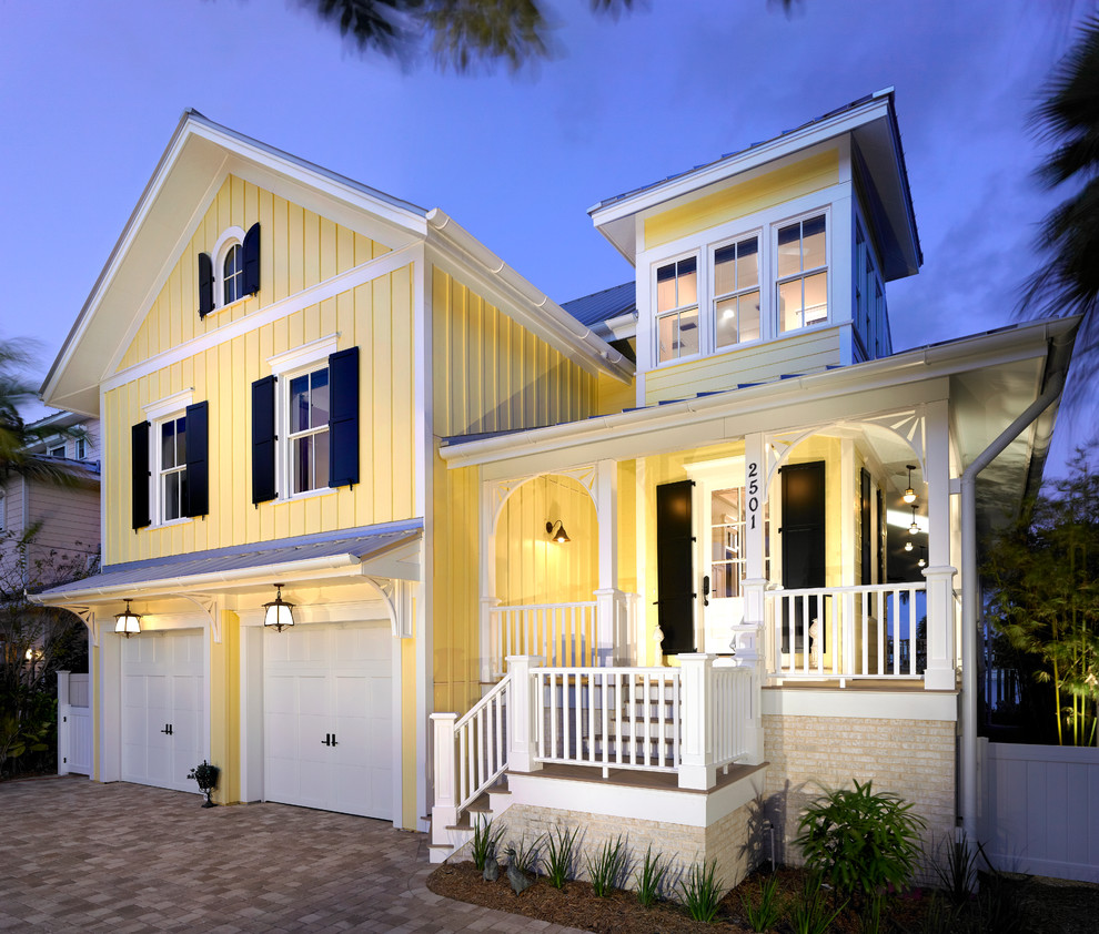 Идея дизайна: большой, двухэтажный, деревянный, желтый частный загородный дом в морском стиле с плоской крышей и крышей из гибкой черепицы