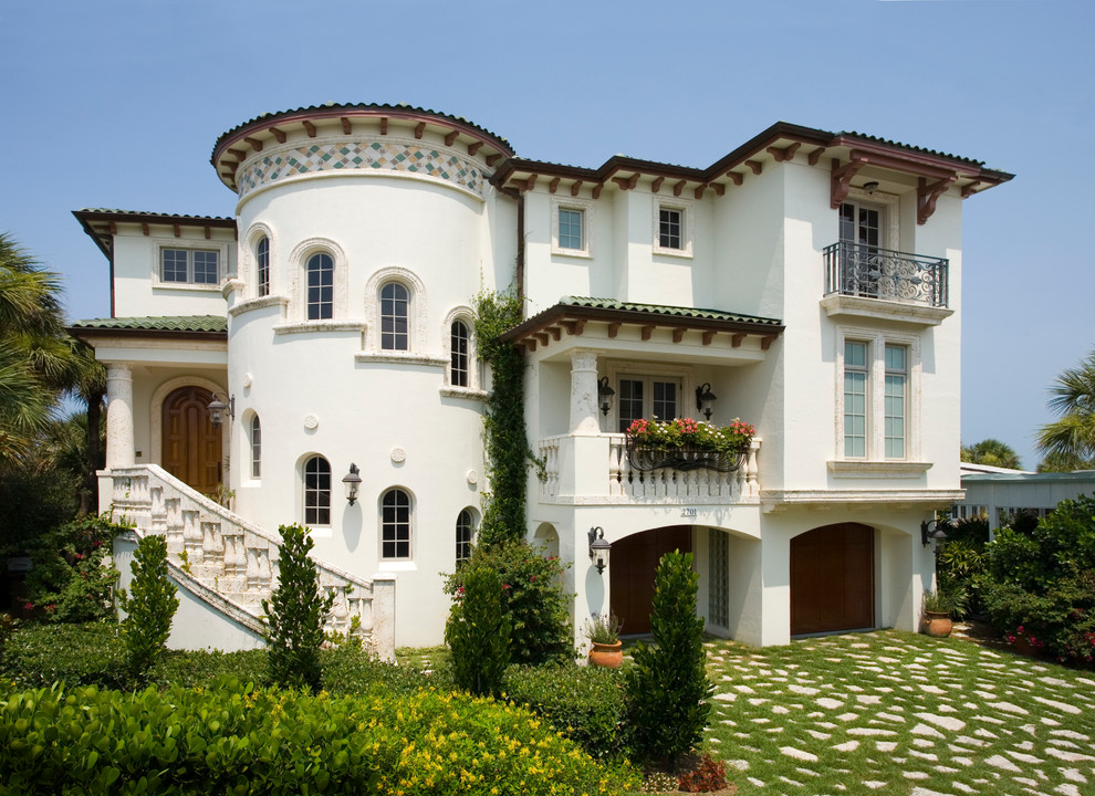 Пример оригинального дизайна: трехэтажный, белый частный загородный дом среднего размера в средиземноморском стиле с облицовкой из цементной штукатурки, плоской крышей и черепичной крышей