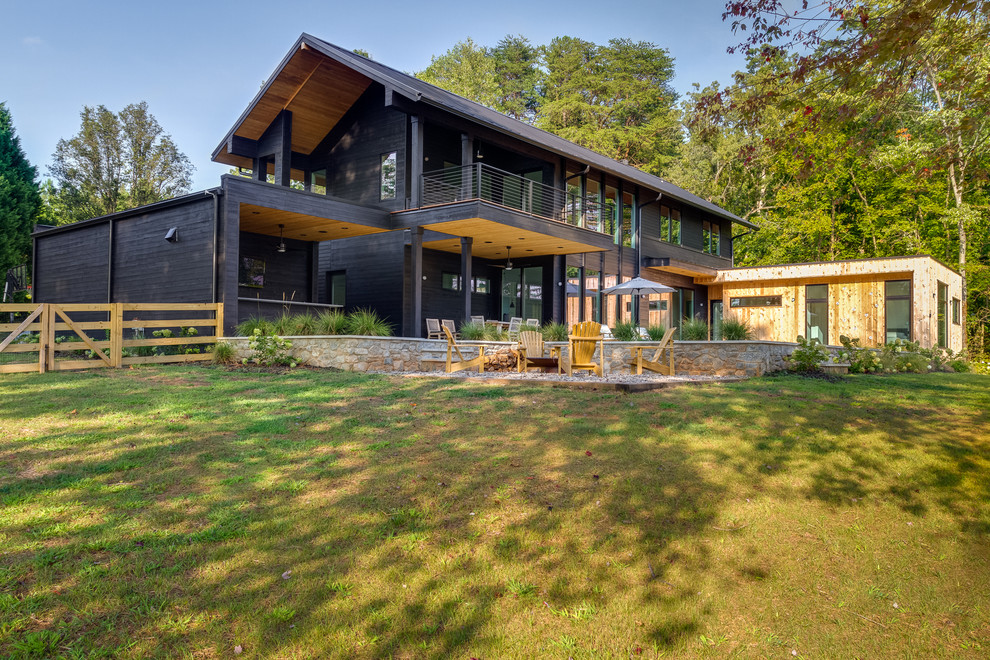 Large danish black two-story wood house exterior photo in Charlotte with a mixed material roof