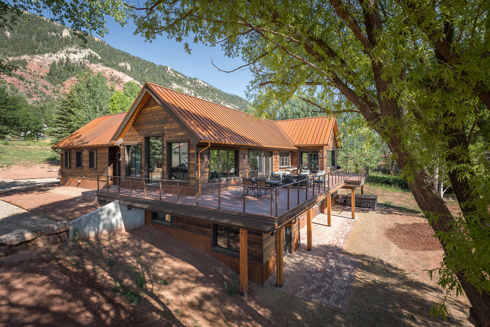 Идея дизайна: двухэтажный, деревянный, коричневый частный загородный дом в стиле рустика с двускатной крышей и металлической крышей